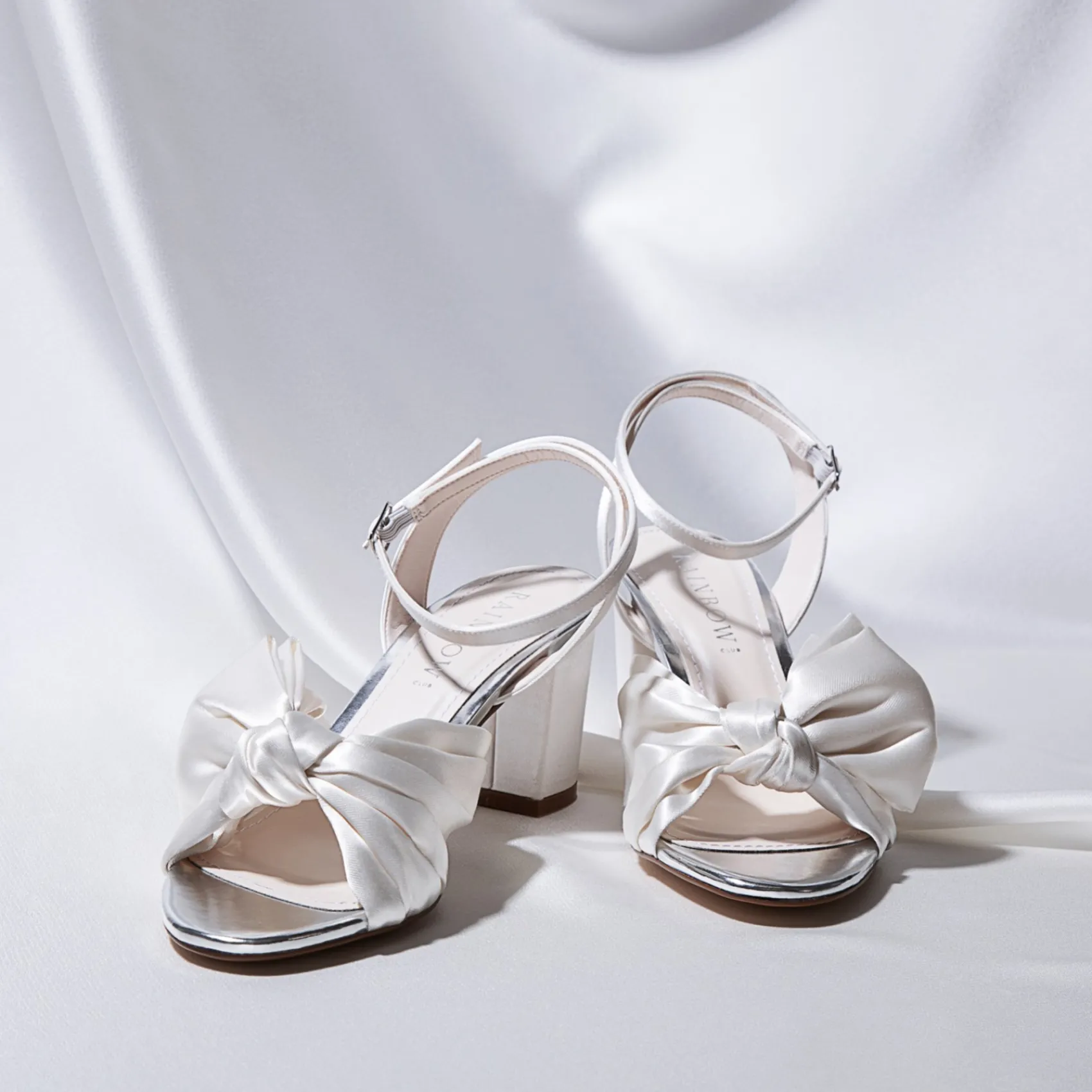 Rainbow Club Arabella Elfenbeinfarbene Satin Sandalen mit asymmetrischer Schleife und Blockabsatz* Hochzeitsschuhe | Schuhe Mit Mittlerem Absatz